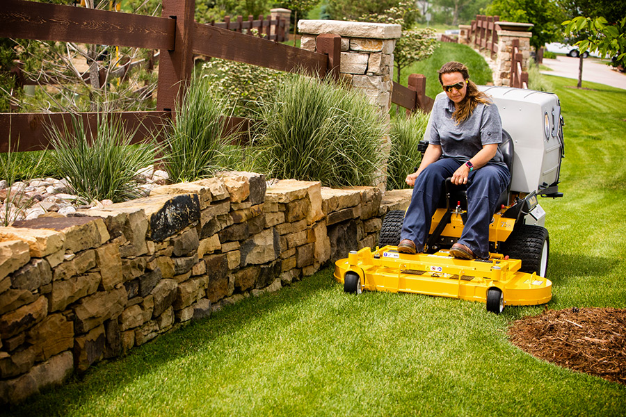 Rider Walker 4-nożowym kosiskiem mulczującym M42B podczas precyzyjnego koszenia i mulczowania dużego trawnika przy hotelu Rider Walker 4-nożowym kosiskiem mulczującym M42B podczas precyzyjnego koszenia i mulczowania dużego trawnika przy hotelu